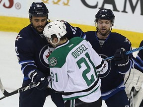 Winnipeg Jets defence men Dustin Byfuglien (left) and Josh Morrissey block Dallas Stars forward Antoine Roussel in front of goaltender Connor Hellebuyck in Winnipeg on Tues., Feb. 14, 2017. Kevin King/Winnipeg Sun/Postmedia Network