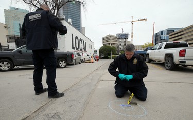Forensic officers collect evidence at the scene of a shooting in the backlane of the 200 blocks of Smith and Garry streets in Winnipeg on Thurs., Sept. 12, 2019. Kevin King/Winnipeg Sun/Postmedia Network