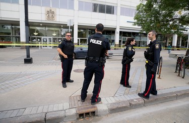 Police officers mill about in front of Winnipeg Police Service headquarters, which was hit from a stray bullet during an early-morning shooting in the backlane of the 200 blocks of Smith and Garry streets in Winnipeg on Thurs., Sept. 12, 2019. Kevin King/Winnipeg Sun/Postmedia Network