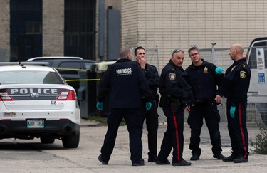 Members of the Winnipeg Police Service forensics department and general patrol officers congregate at the scene of a shooting in the backlane of the 200 blocks of Smith and Garry streets in Winnipeg on Thurs., Sept. 12, 2019. Kevin King/Winnipeg Sun/Postmedia Network