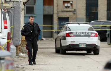 A police officers investigates at the scene of a shooting in the backlane of the 200 blocks of Smith and Garry streets in Winnipeg on Thurs., Sept. 12, 2019. Kevin King/Winnipeg Sun/Postmedia Network
