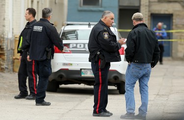 A police officer interviews a man who was at work in the former Pint Public House, which is transforming into a Local Public Eatery, at the scene of a shooting in the backlane of the 200 blocks of Smith and Garry streets in Winnipeg on Thurs., Sept. 12, 2019. Kevin King/Winnipeg Sun/Postmedia Network