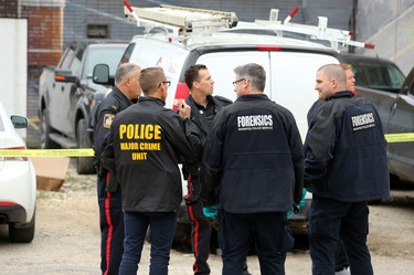 Members of the Winnipeg Police Service major crimes, forensics and general patrol officers congregate at the scene of a shooting in the backlane of the 200 blocks of Smith and Garry streets in Winnipeg on Thurs., Sept. 12, 2019. Kevin King/Winnipeg Sun/Postmedia Network