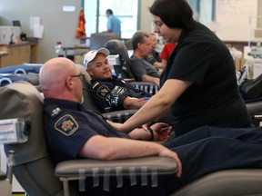 Justin Kelsch (second from left), Union of Canadian Correctional Officers president at Stony Mountain Institution checks on regional president James Bloomfield (left) as they donate blood at Canadian Blood Services on William Avenue in Winnipeg on Mon., Sept. 16, 2019. Kevin King/Winnipeg Sun/Postmedia Network