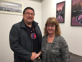 (Left to right) Pimicikamak Indigenous nation Chief David Monias shakes hands with Maple Bus Lines President Lori Mann following the announcement on Friday in Winnipeg that Pimicikamak has become a strategic investor in the Manitoba bus service.