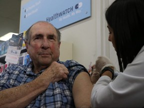 Tom Farrell, the president of the Manitoba Association of Senior Centres is given a flushot by pharmacist Pawandeep Sidhu during the department's kick off to their flu shot campaign at a Shoppers Drug Mart at Grant Park in Winnipeg on Wednesday, Oct. 24, 2019. Josh Aldrich/Winnipeg Sun/Postmedia