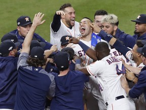The Houston Astros celebrate with Carlos Correa after his walk-off solo home run in the 11th inning in Game 2 of the American League Championship Series against the New York Yankees at Minute Maid Park on October 13, 2019 in Houston, Texas. (Photo by Tim Warner/Getty Images)