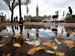 The Peace Tower on Parliament Hill is reflected on a puddle of water in Ottawa, Oct. 23, 2019. (REUTERS/Stephane Mahe)