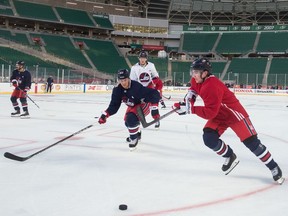 The Winnipeg Jets practice on the ice at Mosaic Stadium in Regina on Friday, the day before the NHL Heritage Classic hockey game.