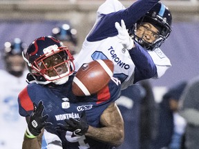 Alouettes’ Quan Bray (left) tries to haul in a pass while Argonauts’ Qudarius Ford defends on Friday night in Montreal. (GRAHAM HUGHES/THE CANADIAN PRESS)