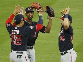 Juan Soto (left), Michael A. Taylor (top) and Gerardo Parra of the Washington Nationals celebrate their 12-3 win over the Houston Astros in Game 2 of the 2019 World Series at Minute Maid Park on Oct. 23, 2019 in Houston,. (BOB LEVEY/Getty Images)