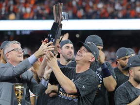 Astros Manager A.J. Hinch (right) celebrates with the trophy following Houston's 6-4 win over the New York Yankees in Game 6 of the ALCS on Saturday night. (Elsa/Getty Images)