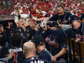 Atlanta Braves shortstop Dansby Swanson, bottom left, celebrates with third baseman Josh Donaldson, top right, and teammates after scoring against the St. Louis Cardinals during the ninth inning in game three of the 2019 NLDS playoff baseball series at Busch Stadium. (Jeff Curry-USA TODAY Sports)