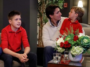 Liberal leader and Prime Minister Justin Trudeau watches a television broadcast of the initial results from the federal election with his sons Xavier and Hadrien, in Montreal, Oct. 21, 2019. (REUTERS/Stephane Mahe)