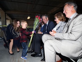 With a little urging from mother Melissa, James Burns, a Children's Heart Centre patient, presents flowers to Barb Price as her husband Gerry (right) and Premier Brian Pallister smile during a press conference at Children's Hospital in Winnipeg to announce that fundraising for a new pediatric cardiac centre is near completion on Tuesday.