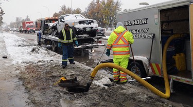 A Dr. Hook Emergency Response crew cleans up after a Ford Ranger hit a light standard and had its gas tank ripped open on Kenaston Boulevard near Tuxedo Avenue in Winnipeg on Thurs., Oct. 10, 2019. Kevin King/Winnipeg Sun/Postmedia Network