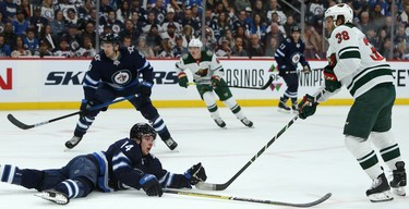 Winnipeg Jets defenceman Ville Heinola (bottom left) reacts after his turnover lead to a goal from Minnesota Wild forward Ryan Hartman during NHL action in Winnipeg on Thurs., Oct. 10, 2019. Kevin King/Winnipeg Sun/Postmedia Network