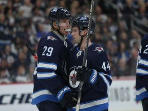 Winnipeg Jets forward Patrik Laine (left) speaks with defenceman Josh Morrissey during a break in NHL action against the Minnesota Wild in Winnipeg on Thursday, Oct. 10, 2019. The Jets will be without Laine and Morrissey when they take on the high-powered Edmonton Oilers Saturday night.