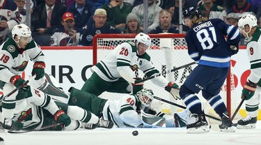 Winnipeg Jets forward Kyle Connor (81) cannot find a loose puck in front of Minnesota Wild goaltender Devan Dubnyk and defenceman Ryan Suter (20) during NHL action in Winnipeg on Thurs., Oct. 10, 2019. Kevin King/Winnipeg Sun/Postmedia Network