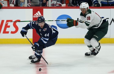 Winnipeg Jets defenceman Josh Morrissey (left) skates away from Minnesota Wild forward Jordan Greenway during NHL action in Winnipeg on Thurs., Oct. 10, 2019. Kevin King/Winnipeg Sun/Postmedia Network