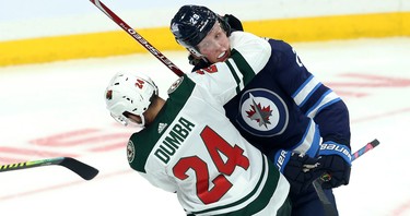 Winnipeg Jets forward Patrik Laine (top) is grabbed by Minnesota Wild defenceman Matt Dumba during NHL action in Winnipeg on Thurs., Oct. 10, 2019. Kevin King/Winnipeg Sun/Postmedia Network