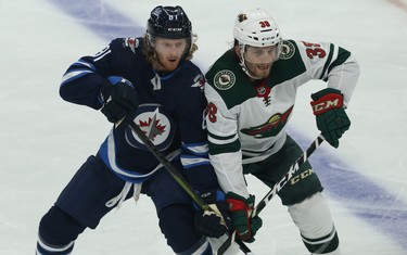 Winnipeg Jets forward Kyle Connor (left) and Minnesota Wild forward Ryan Hartman battle for space during NHL action in Winnipeg on Thurs., Oct. 10, 2019. Kevin King/Winnipeg Sun/Postmedia Network