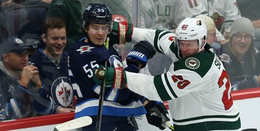 Winnipeg Jets centre Mark Scheifele (left) is checked by Minnesota Wild defenceman Ryan Suter during NHL action in Winnipeg on Thurs., Oct. 10, 2019. Kevin King/Winnipeg Sun/Postmedia Network