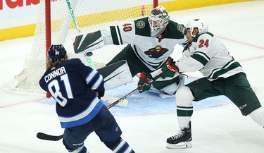 Winnipeg Jets forward Kyle Connor (left) pots the game-winning goal past Minnesota Wild goaltender Devan Dubnyk with defenceman Matt Dumba defending during NHL action in Winnipeg on Thurs., Oct. 10, 2019. Kevin King/Winnipeg Sun/Postmedia Network