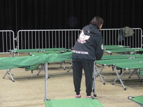 Volunteers from the Canadian Red Cross and the Bear Clan Patrol set up cots in the RBC Convention Centre in Winnipeg on Sunday.
