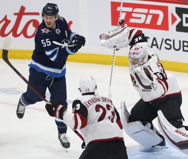 Winnipeg Jets centre Mark Scheifele (left) avoids a high shot that is saved by Phoenix Coyotes goaltender Darcy Kuemper during NHL action in Winnipeg on Tues., Oct. 15, 2019. Kevin King/Winnipeg Sun/Postmedia Network