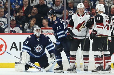 Winnipeg Jets goaltender Connor Hellebuyck (left) looks up at Josh Morrissey after a clearing attempt went into the Jets net during NHL action against the Phoenix Coyotes in Winnipeg on Tues., Oct. 15, 2019. Christian Dvorak (18) was credited with the goal. Kevin King/Winnipeg Sun/Postmedia Network
