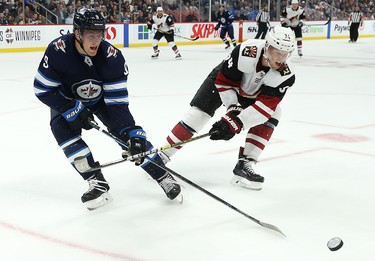 Winnipeg Jets centre Andrew Copp (left) and Phoenix Coyotes centre Carl Soderberg whack at a loose puck during NHL action in Winnipeg on Tues., Oct. 15, 2019. Kevin King/Winnipeg Sun/Postmedia Network