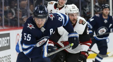 Winnipeg Jets centre Mark Scheifele (left) chases a loose puck with Phoenix Coyotes defenceman Jason Demers at his heels during NHL action in Winnipeg on Tues., Oct. 15, 2019. Kevin King/Winnipeg Sun/Postmedia Network