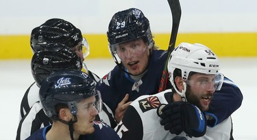 Winnipeg Jets forward Patrik Laine, sporting a gash on his chin, ties up Phoenix Coyotes defenceman Jason Demers during a scrum during NHL action in Winnipeg on Tues., Oct. 15, 2019. Kevin King/Winnipeg Sun/Postmedia Network