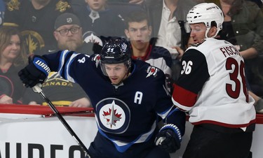 Winnipeg Jets defenceman Josh Morrissey (left) stops Phoenix Coyotes forward Christian Fischer along the boards during NHL action in Winnipeg on Tues., Oct. 15, 2019. Kevin King/Winnipeg Sun/Postmedia Network