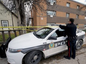 A police officer expands the cordoned-off area in front of a scene of a fatal stabbing at an apartment building at 345 Talbot Avenue in Winnipeg on Wed., Oct. 23, 2019. Kevin King/Winnipeg Sun/Postmedia Network