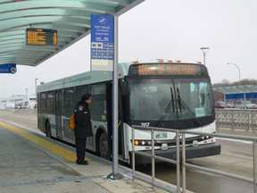 Passengers board a Winnipeg Transit bus at the Southwest Transitway Fort Rouge Station.