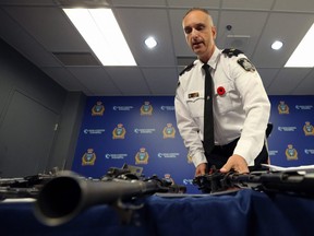Insp. Max Waddell handles a Browning machine gun during a press conference at Winnipeg police headquarters on Smith Street to unveil a cache of weapons seized from a Winnipeg home in mid-October, on Wed., Oct. 30, 2019.  Kevin King/Winnipeg Sun/Postmedia Network
