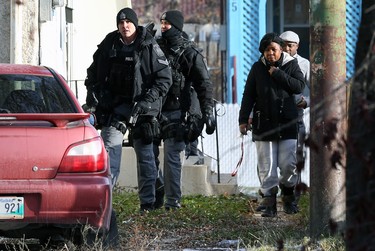 Tactical team members escort a man and woman out of a multi-unit dwelling that is the scene of an apparent armed and barricaded incident on Pacific Avenue between Ellen and Paulin streets in Winnipeg on Thurs., Oct. 31, 2019. A man and woman got into a vehicle and drove away. An armoured vehicle was on scene, as well as a police negotiator and an ambulance on standby for what police say came in as an armed robbery call just before 5 a.m. on Thursday morning. Officers could be heard using a megaphone asking people inside the home to come out with their arms in the air. Kevin King/Winnipeg Sun/Postmedia Network