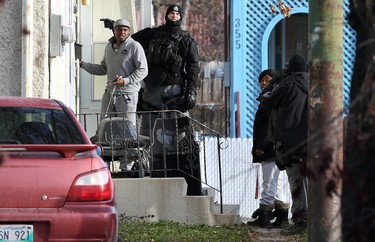 Tactical team members escort a man and woman out of a multi-unit dwelling that is the scene of an apparent armed and barricaded incident on Pacific Avenue between Ellen and Paulin streets in Winnipeg on Thurs., Oct. 31, 2019. A man and woman got into a vehicle and drove away. An armoured vehicle was on scene, as well as a police negotiator and an ambulance on standby for what police say came in as an armed robbery call just before 5 a.m. on Thursday morning. Officers could be heard using a megaphone asking people inside the home to come out with their arms in the air. Kevin King/Winnipeg Sun/Postmedia Network