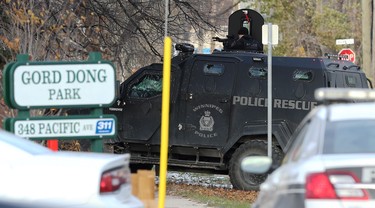 A tactical team member trains a weapon at a multi-unit dwelling that is the scene of an apparent armed and barricaded incident on Pacific Avenue between Ellen and Paulin streets in Winnipeg on Thurs., Oct. 31, 2019. A police negotiator and an ambulance on standby were also on scene for what police say came in as an armed robbery call just before 5 a.m. on Thursday morning. Officers could be heard using a megaphone asking people inside the home to come out with their arms in the air. Kevin King/Winnipeg Sun/Postmedia Network