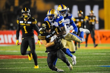 CALGARY, AB - NOVEMBER 24: Jaelon Acklin #80 of the Hamilton Tiger-Cats runs the ball against Brandon Alexander #37 of the Winnipeg Blue Bombers during the 107th Grey Cup Championship Game at McMahon Stadium on November 24, 2019 in Calgary, Alberta, Canada. (Photo by Derek Leung/Getty Images)