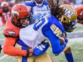 Stampeders Nate Holley stops Winnipeg Blue Bombers Janarion Grant during the CFL's West Division semifinal at McMahon Stadium on Sunday.  Azin Ghaffari/Postmedia Network