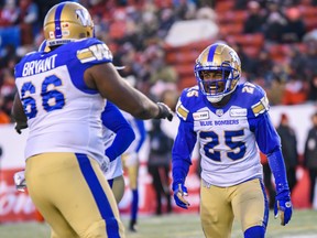 Winnipeg Blue Bombers Nick Taylor celebrates with offensive lineman Stanley Bryant during the CFL's West Division semifinal against Calgary Stampeders at McMahon Stadium on Sunday.