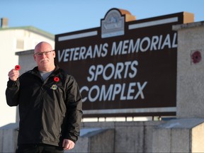 CJ Butcher, who is a retired warrant officer with the Royal Canadian Air Force, holds out a poppy as he stands next to the Veterans Memorial Sports Complex in Stonewall. Butcher runs CJ's Edge Workx at the local arena.