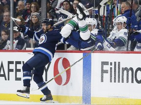 Vancouver Canucks' Alexander Edler goes over the boards as he misses the check on Winnipeg Jets' Mathieu Perreault during second period NHL action in Winnipeg, Friday, Nov. 8, 2019. THE CANADIAN PRESS/John Woods