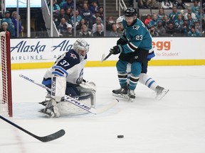 Winnipeg Jets goaltender Connor Hellebuyck blocks a shot by Sharks centre Barclay Goodrow during last night’s game in San Jose. 
(AP Photo/Tony Avelar)