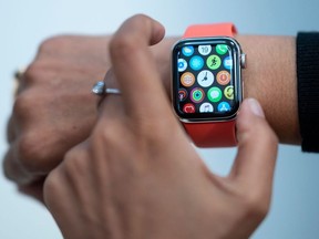 In this file photo taken on September 19, 2019 An employee demonstrate the new Apple watch inside the newly renovated Apple Store at Fifth Avenue on September 19, 2019 in New York City.