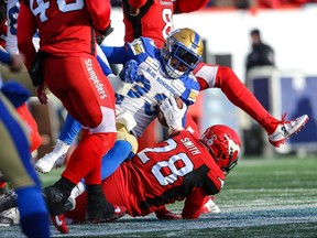 Winnipeg Blue Bombers Andrew Harris is tackled by Brandon Smith of the Calgary Stampeders during the CFL West Division semifinal in Calgary on Sunday, November 10, 2019. Al Charest/Postmedia