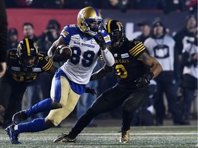 Winnipeg Blue Bombers wide receiver Rasheed Bailey (88) runs with the ball after a catch as Hamilton Tiger-Cats defensive back Frankie Williams (37) defends with defensive back Rico Murray (0) in the first half during the 107th Grey Cup championship football game at McMahon Stadium. Mandatory Credit: Eric Bolte-USA TODAY Sports